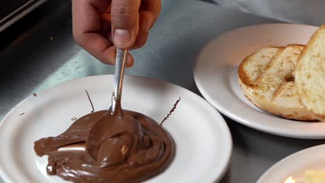 el chef untó nutella en medio pan tostado con crema de avellanas