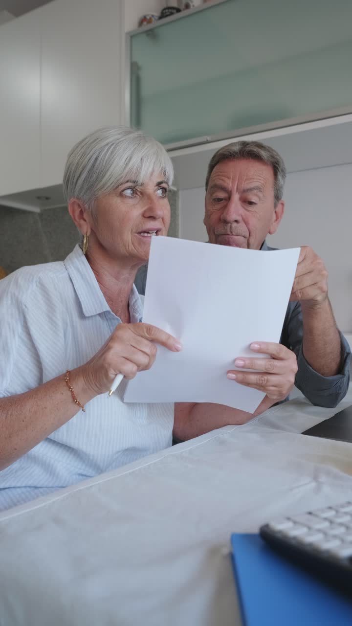 Senior couple reviewing paperwork at home