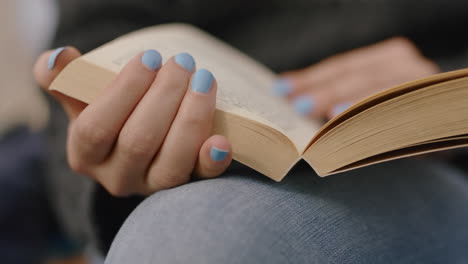 Cerrar-Las-Manos-Mujer-Leyendo-Un-Libro-En-La-Playa-Disfrutando-De-La-Historia-Pasando-La-Página-De-La-Novela