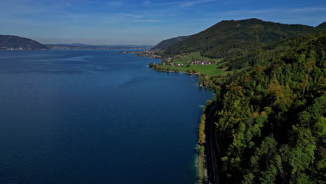 attersee lake in austria with a picturesque village by the forest - aerial view