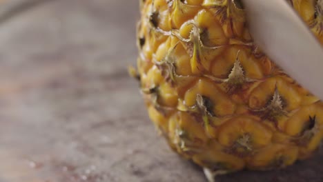 closeup of knife cutting pineapple