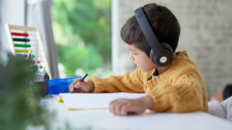 Boy-child,-homework-and-writing-with-headphones