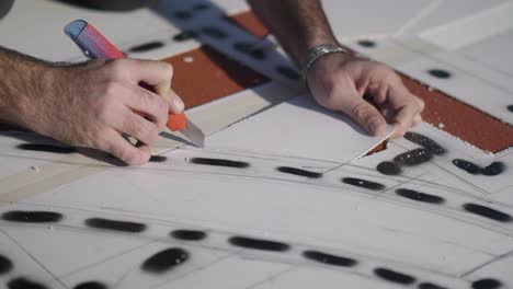 hands measure and cut lines on building plan in precision architectural design process for stencil creation