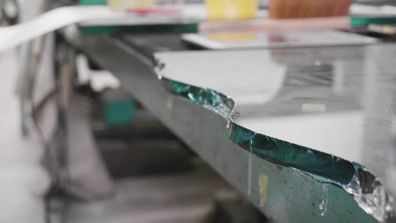 la cámara lenta de las pinzas quita un trozo de vidrio en forma de onda durante el corte de vidrio