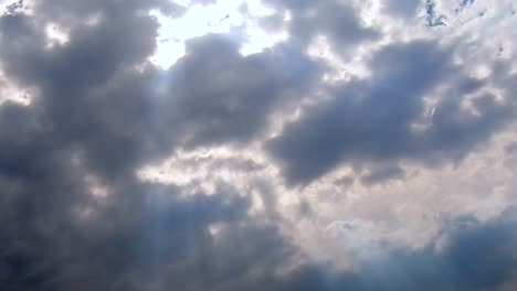 fluffy cloud sky above with sun rays shinning through , summer day