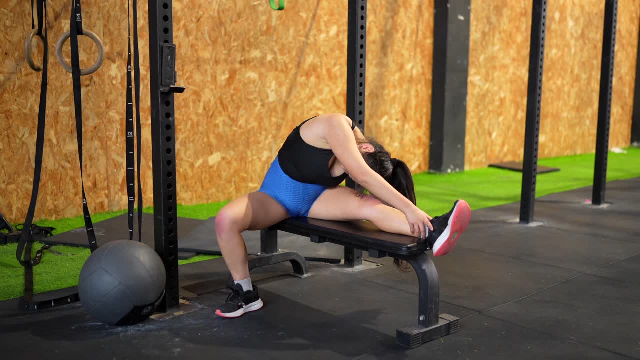 mujer estirándose en el gimnasio
