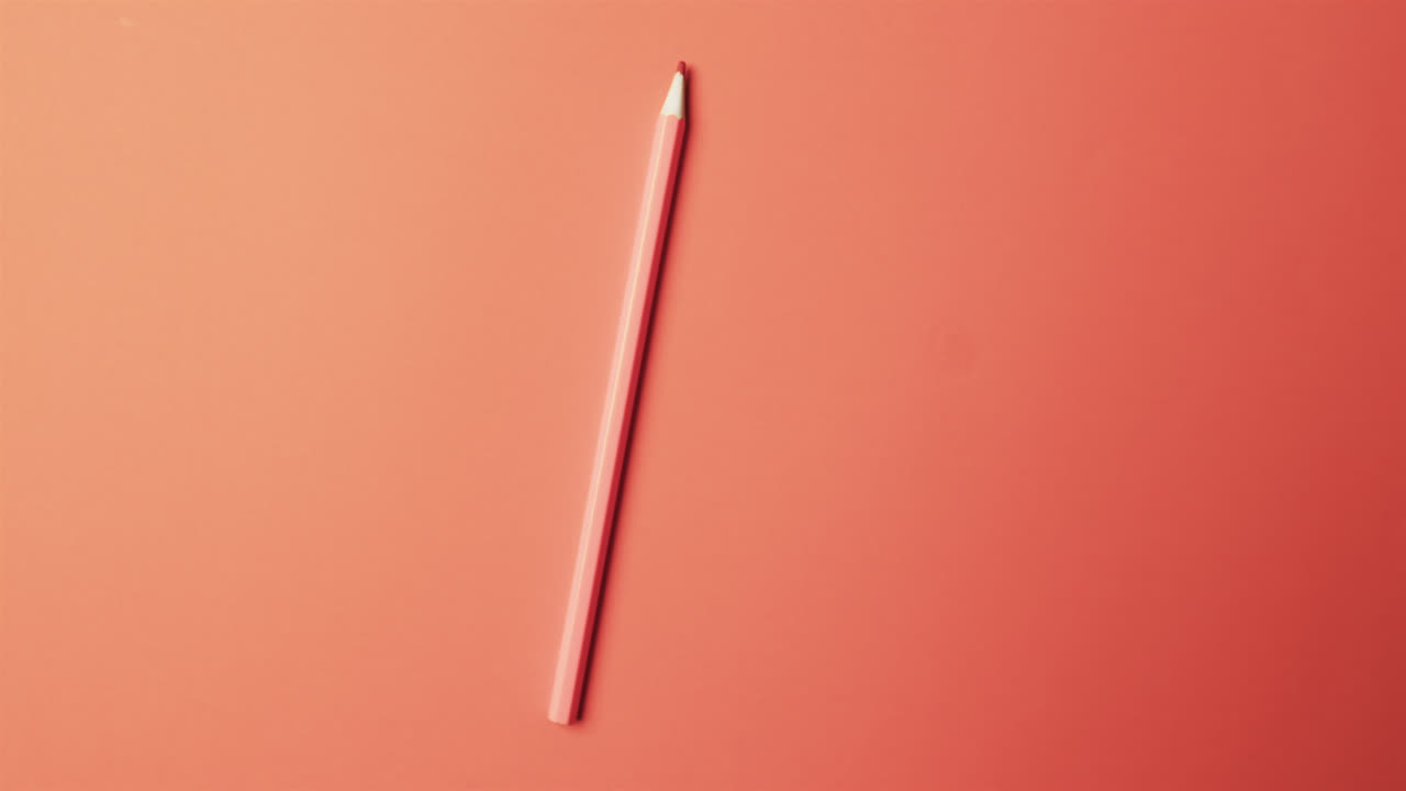 vista aérea de un lápiz rojo con espacio de copia en fondo rojo, en cámara lenta