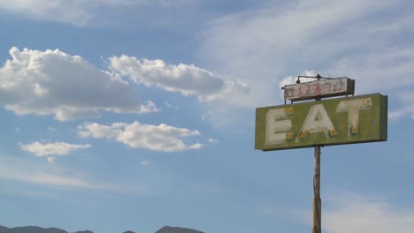 Ein-Altes-Nostalgisches-Schild-Sagt,-In-Einem-Diner-Essen,-Während-Wolken-Vorbeiziehen