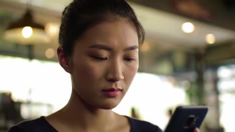 captivated and engaged: a young woman deep in thought while interacting with her smartphone in a cozy cafe environment