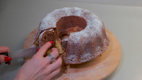 traditional marble cake on wooden plate, cutting a cake into slices