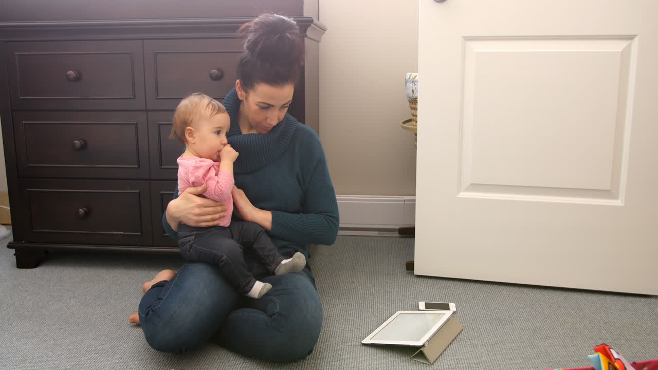 Mother and daughter using digital tablet in bedroom