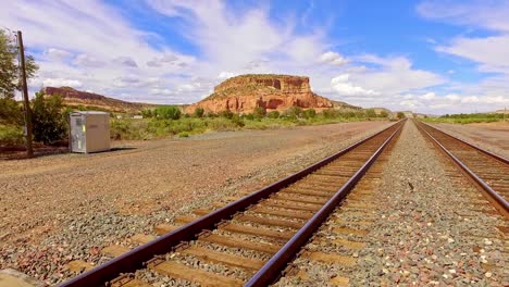 vías ferroviarias a lo lejos en el desierto de arizona, cielos azules y nubes blancas hinchadas.