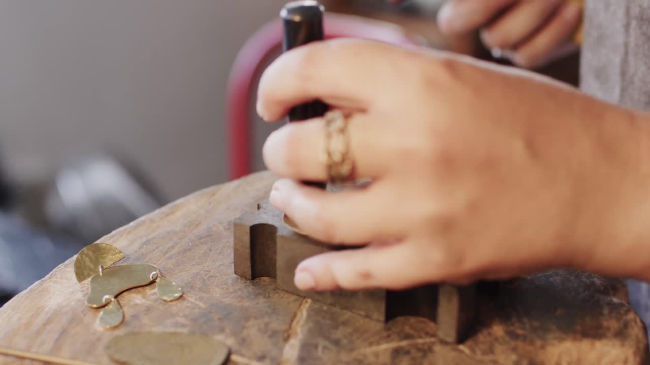 trabajadora caucásica dando forma a las joyas en el estudio en cámara lenta