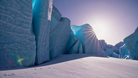 sunburst over towering blue ice walls in a frozen landscape