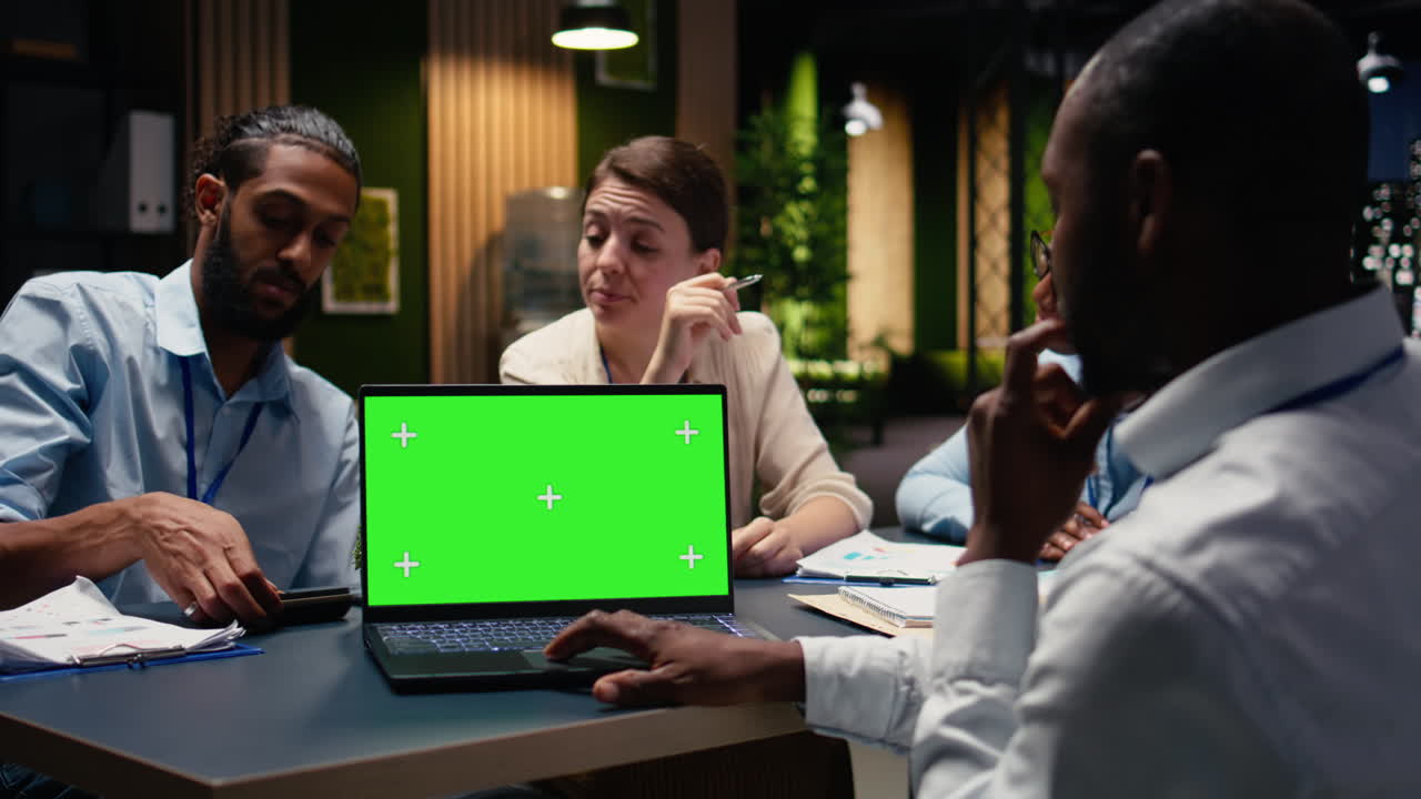 Laptop chroma key terisolasi di depan manajer dan tim multirasial