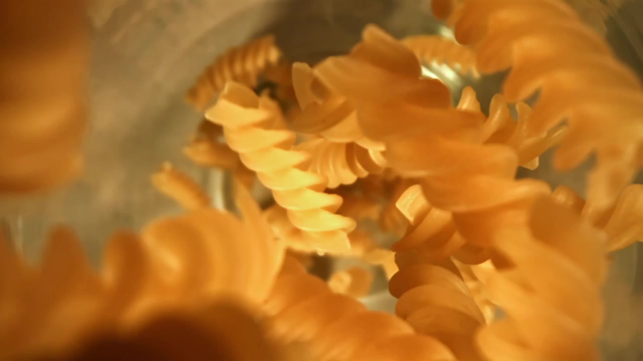 Dry Fusilli Pasta Falling into a Bowl