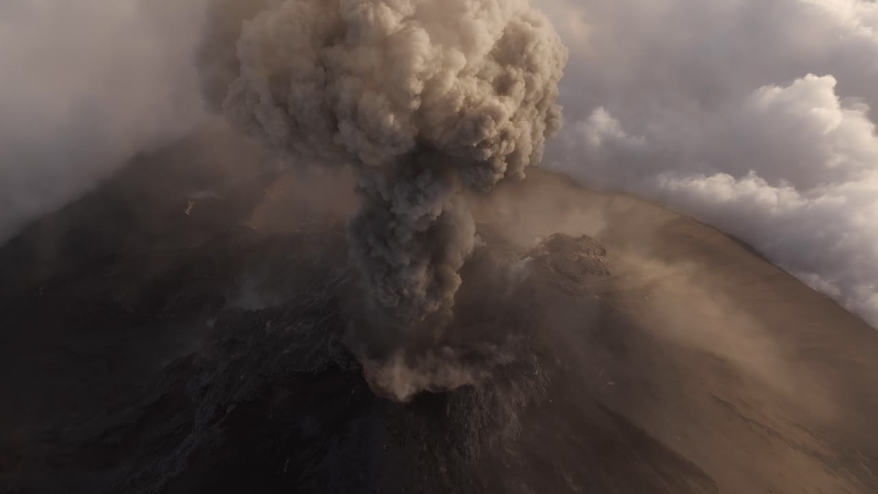 cráter volcánico en erupción, humo dramático que se eleva desde la cumbre del volcán - disparo de avión no tripulado