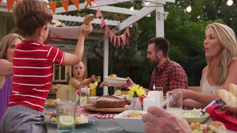 familia de tres generaciones disfrutando del almuerzo al aire libre