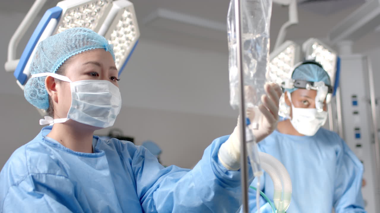 다양한 여성 외과 의사들이 수술실에서 환자를 수술합니다. 느린 동작입니다.