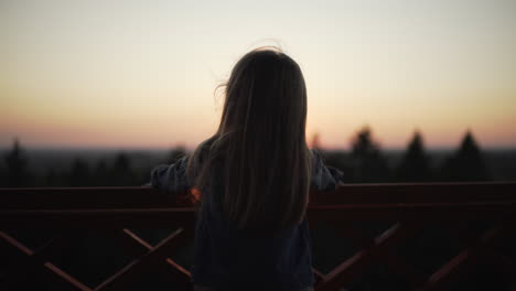 Silueta-De-Niña-De-Pie-En-La-Torre-De-Vigilancia-Al-Atardecer