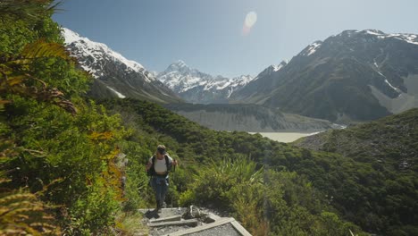 mujer rubia con palos nórdicos para caminar en el sendero de sealy tarns en un día soleado