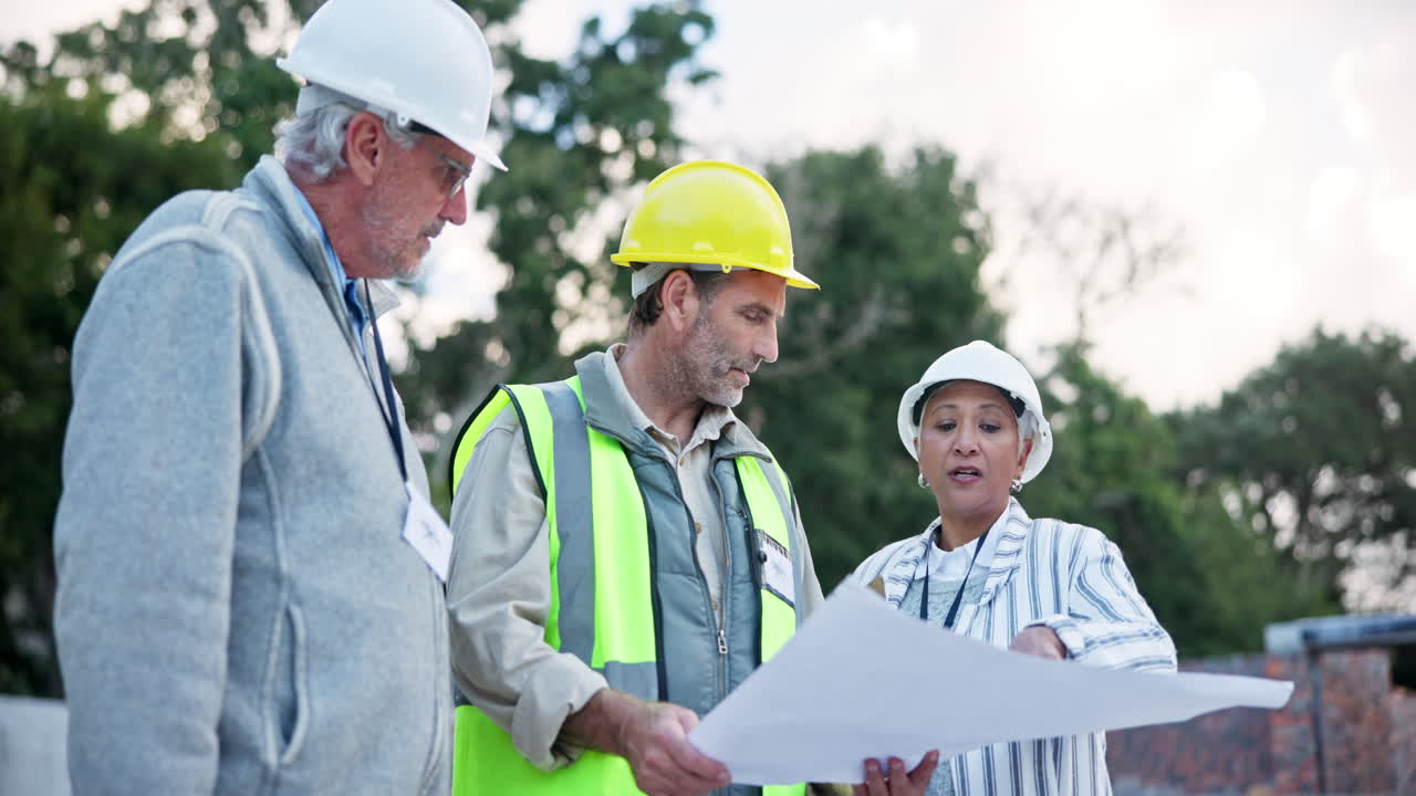 Construction workers discussing blueprints on site