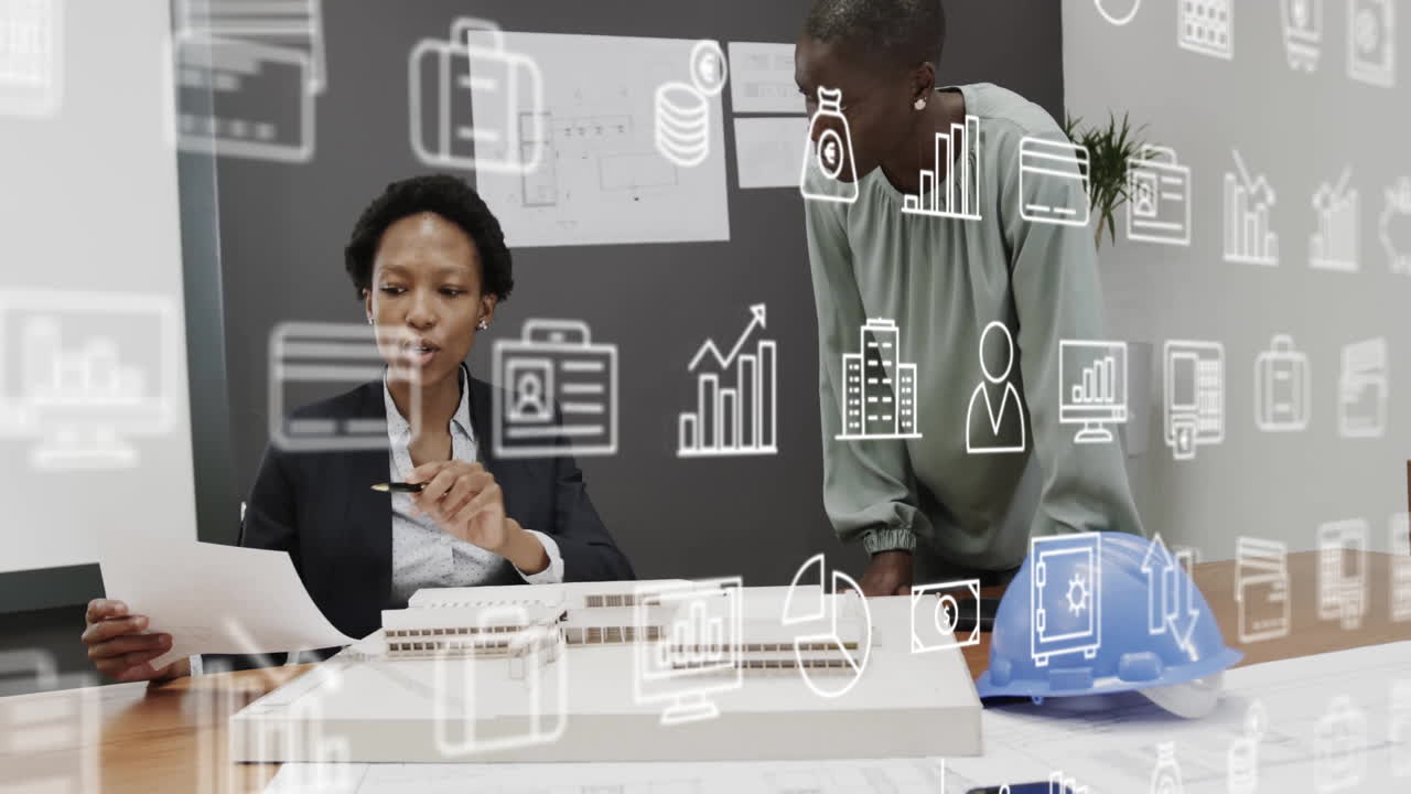 Animation of business icons over diverse business people discussing work in office