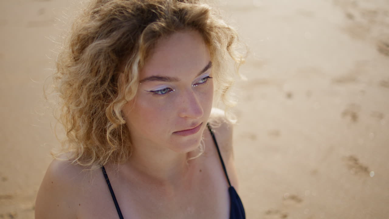 평온한 소녀가 해변에서 휴식을 취하고 은 날씨를 즐기고 있습니다. 초상화 트렌디한 여성