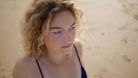 chica tranquila relajándose en la playa disfrutando del tiempo soleado de cerca. retrato de mujer de moda