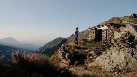 man drinking of cup after exhausted climb on top of mountain