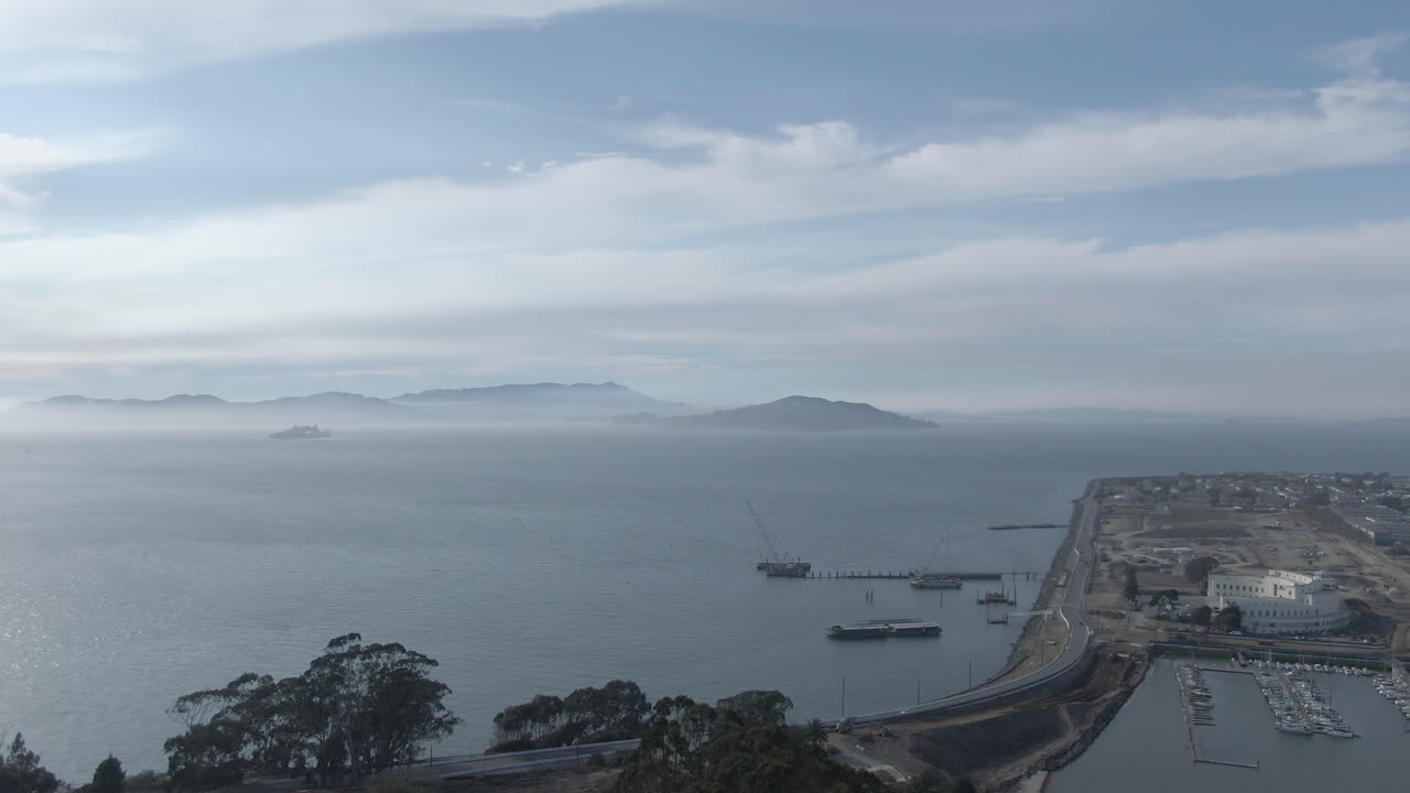 vuelo sobre la isla del tesoro y la isla de yerba buena en la bahía de san francisco en una brumosa tarde de verano - 4k - color plano