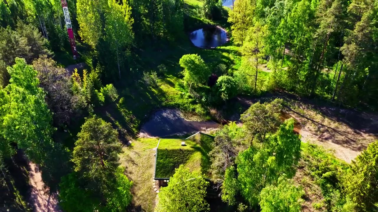 Luftfoto som trekker seg tilbake og avslører Latvia Amatciems, grønn hytte, skog, dammer