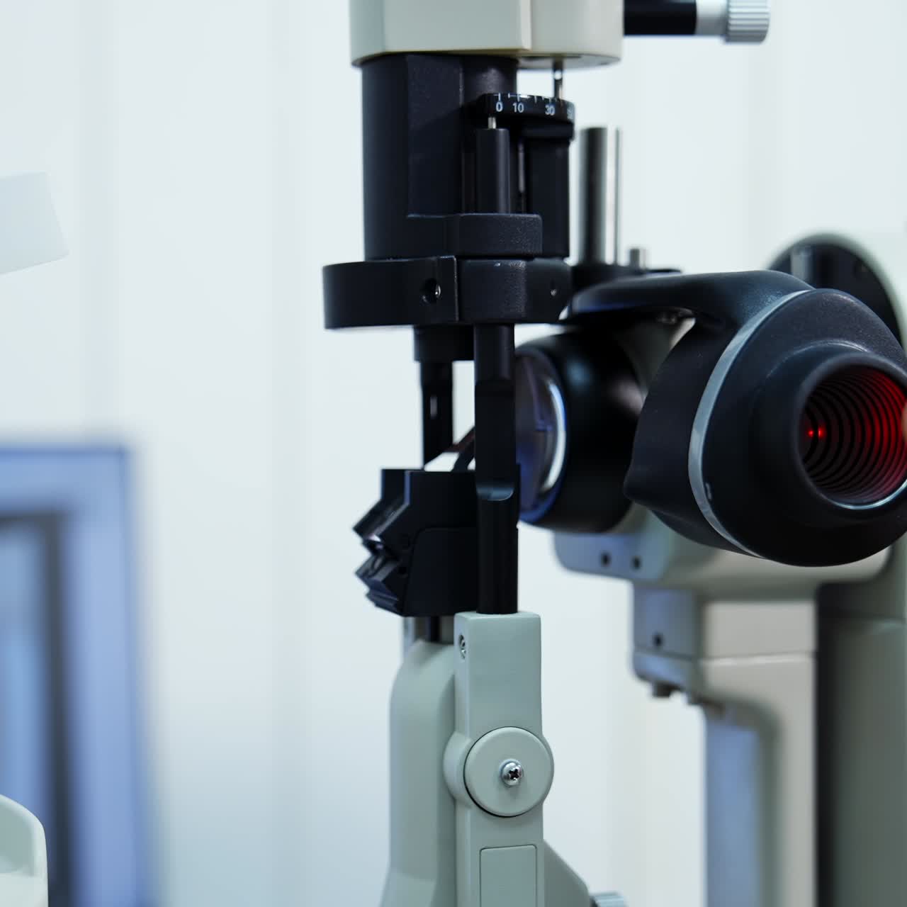 Panning shot of female ophthalmologist`s hand doing eye exam with slit lamp. Preparing special technic for checking eyesight. Selective focus
