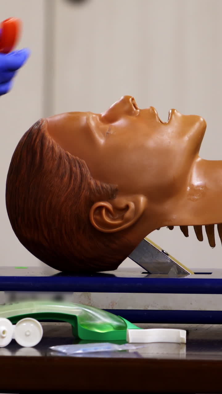 Medical training on a mannequin head. Specialist demonstrates reanimation procedure on a face dummy. Close-up. Vertical video