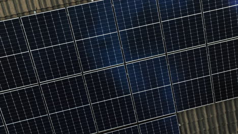 Toma-De-Drones-De-Arriba-Hacia-Abajo-Girando-Sobre-Un-Panel-Solar-Reflectante-En-El-Techo-De-Una-Casa-Moderna