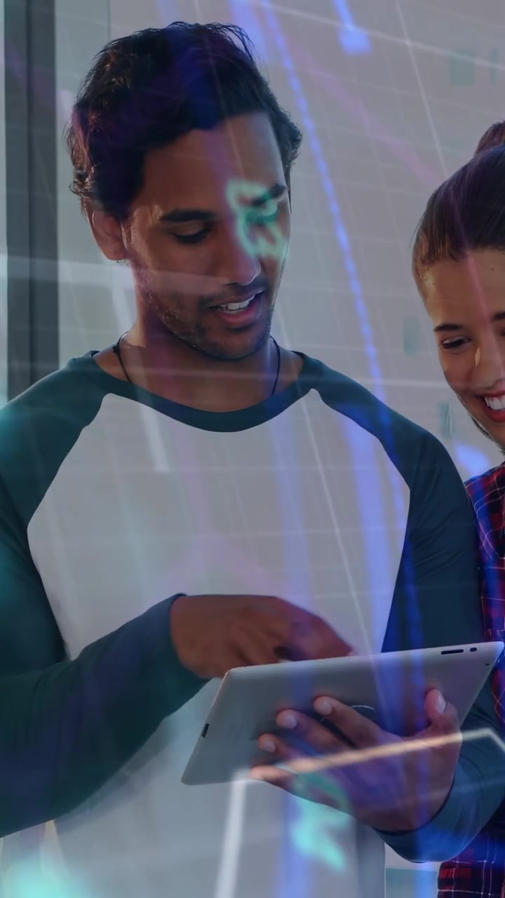Vertical video: Off-frame pointing man with tablet tapping scrolling showing tech overlay over them