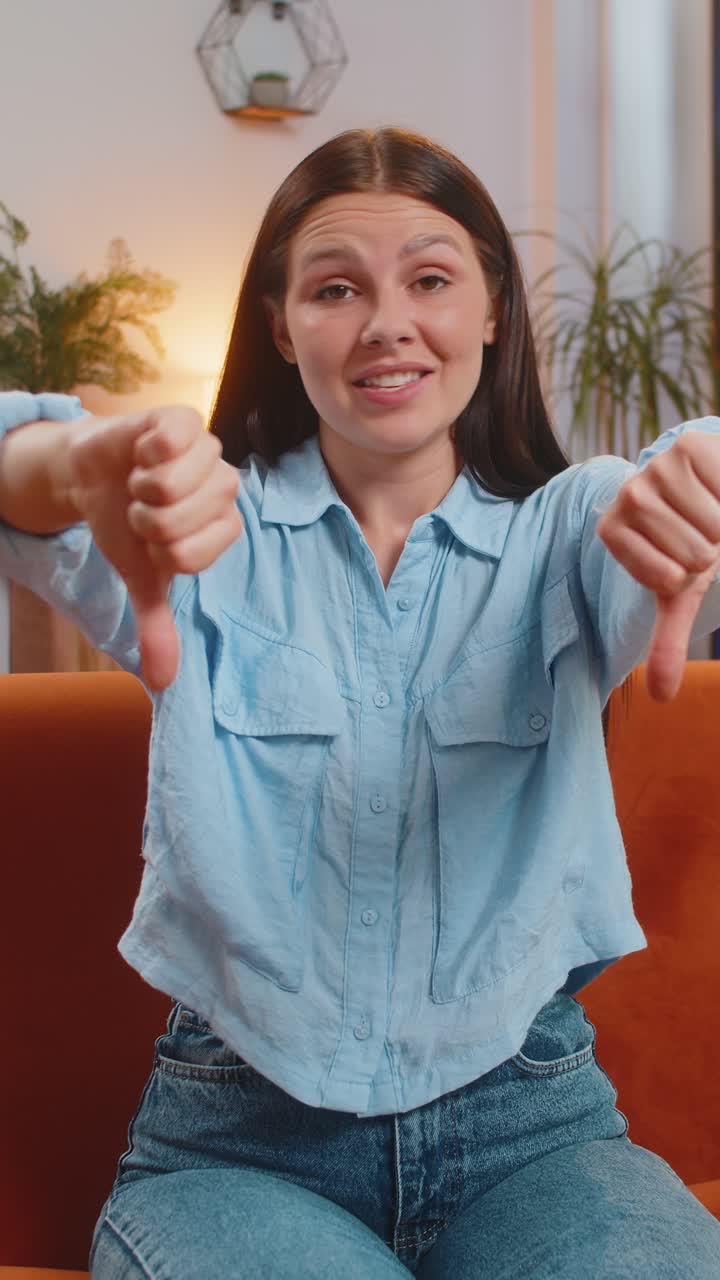 Giovane donna sconvolta e infelice che mostra il pollice verso il basso segno di disapprovazione gesto di disapprovazioni cattivo feedback sul lavoro