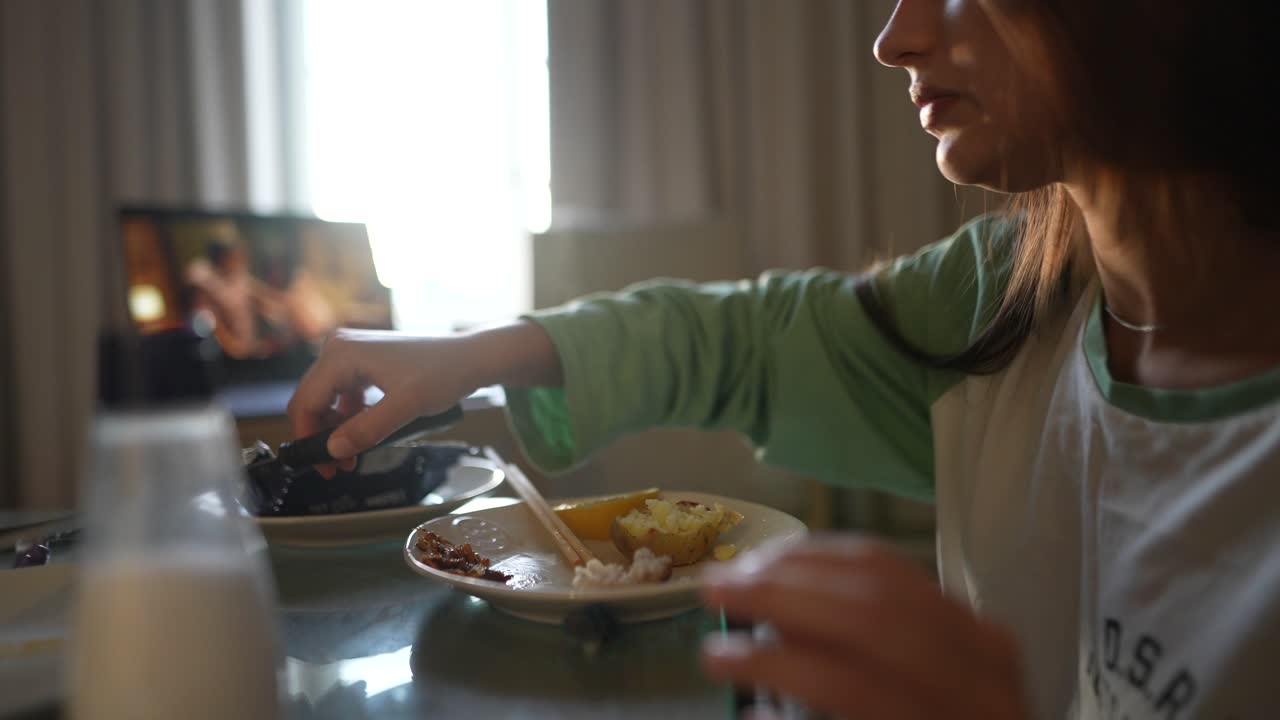 mujer comiendo una comida mientras ve una llamada de video