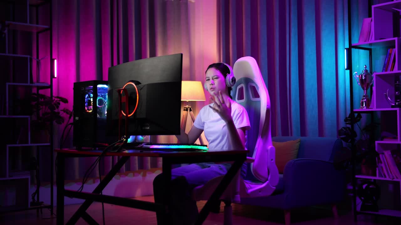 una adolescente asiática pierde mientras juega videojuegos en la computadora.