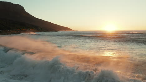 Olas-Oceánicas-Con-Tono-De-Puesta-De-Sol-En-El-Horizonte-En-Camps-Bay,-Ciudad-Del-Cabo,-Sudáfrica