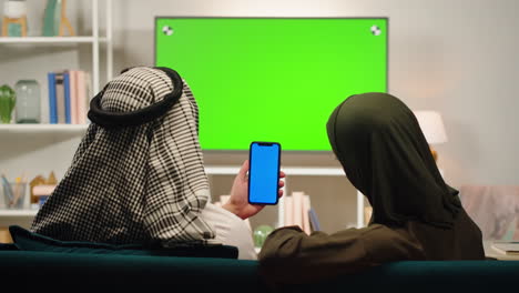 couple watching smartphone in living room