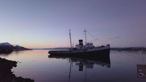 pan right hms justice tug boat sits partially aground at low tide in the beagle channel