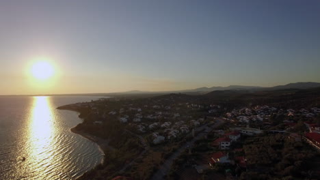 aerial sunset scene of sea and coastline with houses in trikorfo beach greece