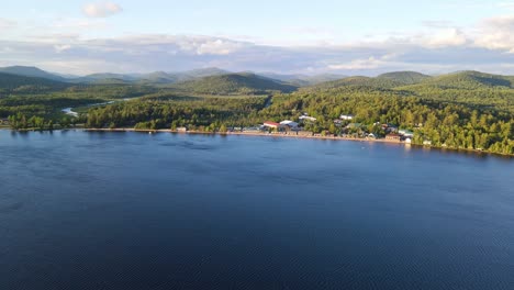 aerial shot of a large lake with rental building alongside the beachfront in new york