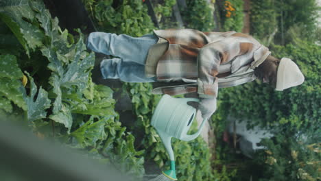 person watering plants in a garden