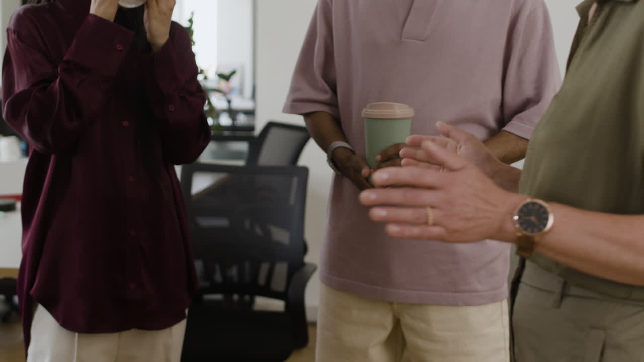 People in an office setting engaged in conversation and a handshake