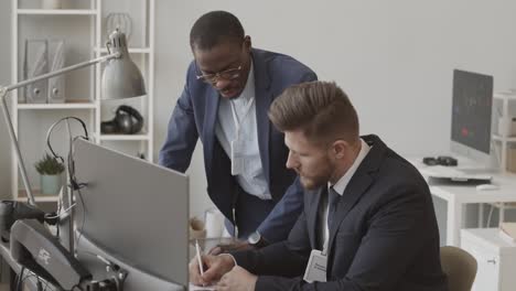 two multiethnic fund managers analyzing stock market in office