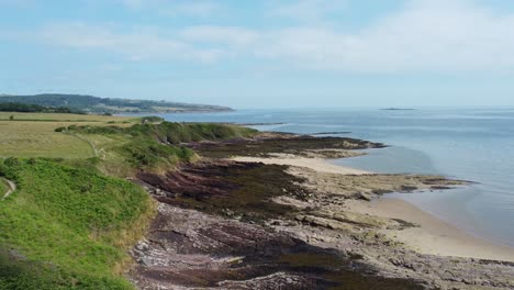 Traeth-Lligwy-Anglesey-eroded-coastal-shoreline-aerial-dolly-view-across-Welsh-weathered-landscape