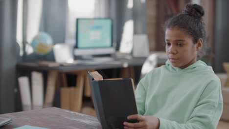 little afro girl reading book at home