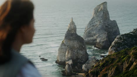 woman overlooking dramatic coastal rocks and ocean